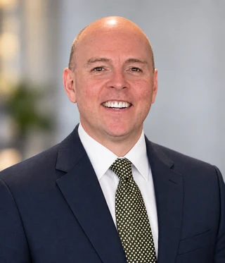 Dr. Eric Christie in a navy suit, professional portrait